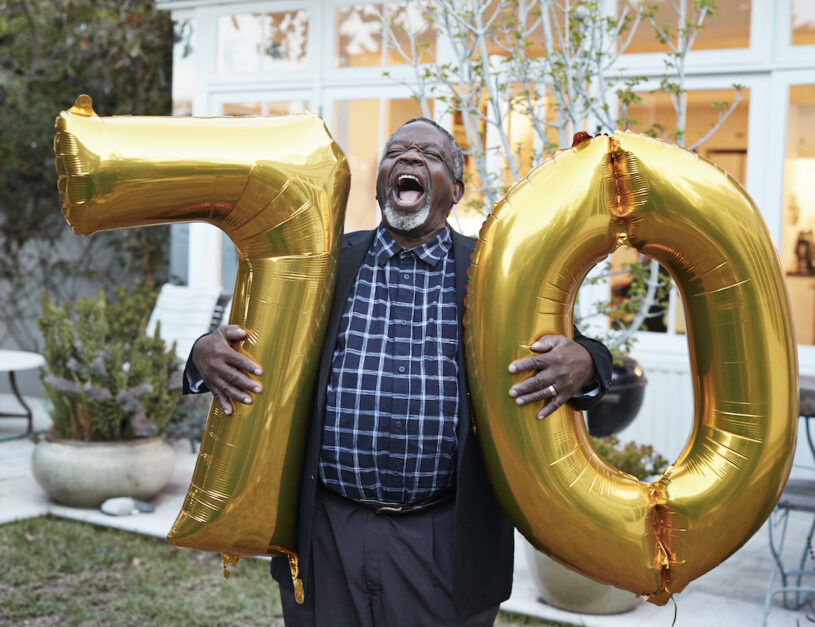 Man laughing and holding balloons
